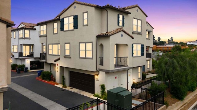 2328 Stardust Gln, Escondido, CA 92025 - view of property featuring stucco siding, a tiled roof, a garage, a balcony, and asphalt driveway