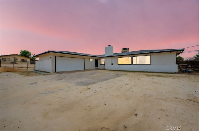 18251 Hiawatha Rd, Apple Valley, CA 92307 - view of front facade featuring an attached garage, a chimney, and stucco siding