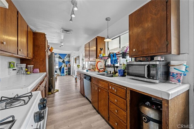 18251 Hiawatha Rd, Apple Valley, CA 92307 - kitchen with appliances with stainless steel finishes, light wood-style floors, a sink, brown cabinetry, and track lighting