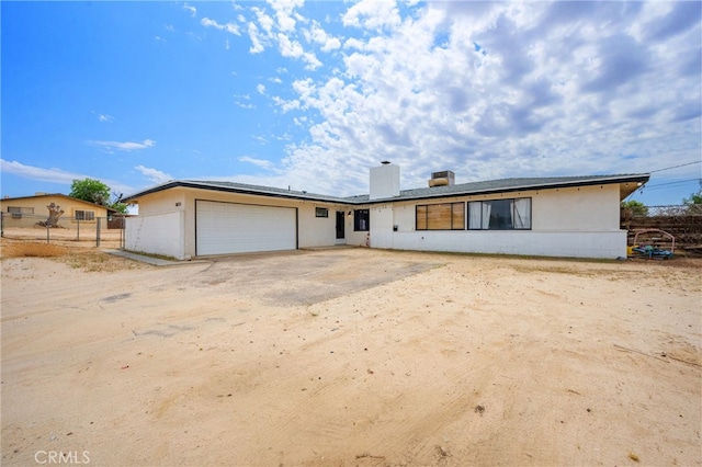 18251 Hiawatha Rd, Apple Valley, CA 92307 - rear view of house with an attached garage, a chimney, and stucco siding