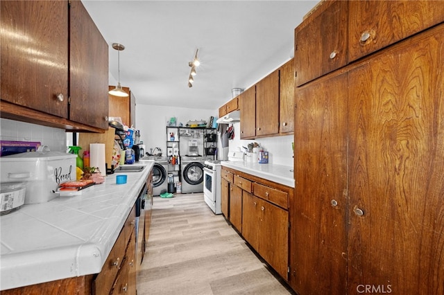 18251 Hiawatha Rd, Apple Valley, CA 92307 - kitchen featuring white range with gas cooktop, washer / dryer, light wood-style flooring, and tile counters