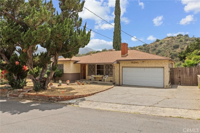 9241 Pali Ave, Tujunga, CA 91042 - ranch-style house with an attached garage, driveway, a chimney, a mountain view, and stucco siding