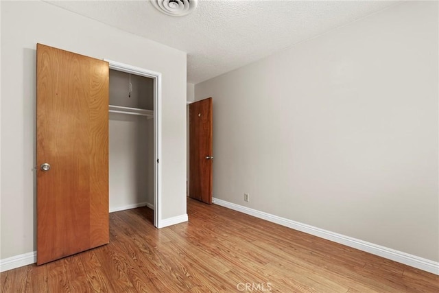 9241 Pali Ave, Tujunga, CA 91042 - unfurnished bedroom with wood finished floors, a closet, baseboards, and a textured ceiling