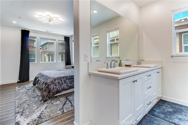 261 Siena, Lake Forest, CA 92630 - ensuite bathroom with baseboards, double vanity, wood finished floors, healthy amount of natural light, and recessed lighting