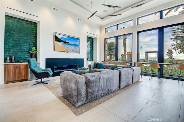 261 Siena, Lake Forest, CA 92630 - living area featuring a high ceiling, a glass covered fireplace, light tile patterned floors, and recessed lighting