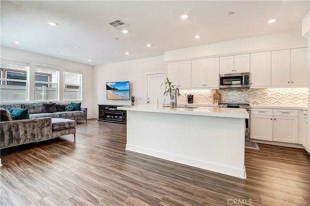 261 Siena, Lake Forest, CA 92630 - kitchen featuring stainless steel appliances, white cabinetry, light countertops, open floor plan, and tasteful backsplash