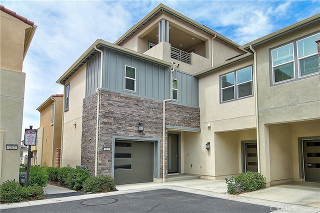 261 Siena, Lake Forest, CA 92630 - view of front of house with stone siding, an attached garage, a balcony, board and batten siding, and stucco siding
