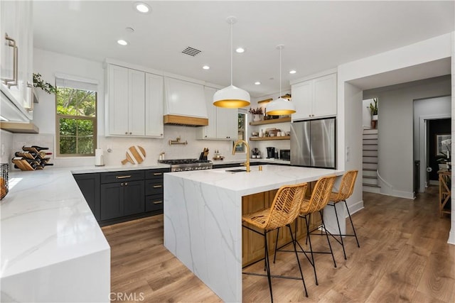 40 Lomada St, Rancho Mission Viejo, CA 92694 - kitchen with freestanding refrigerator, light stone counters, recessed lighting, light wood-style floors, and open shelves