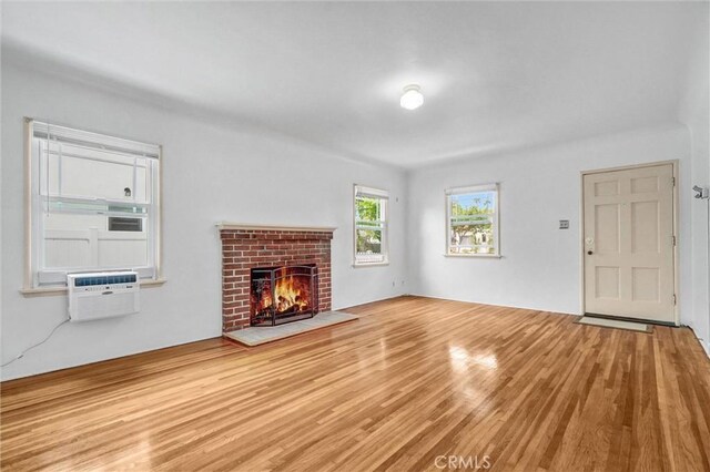 3224 Cerritos Ave, Signal Hill, CA 90755 - unfurnished living room with wood finished floors and a brick fireplace