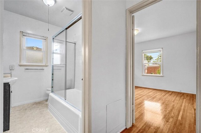 3224 Cerritos Ave, Signal Hill, CA 90755 - bathroom with combined bath / shower with glass door, vanity, and wood finished floors