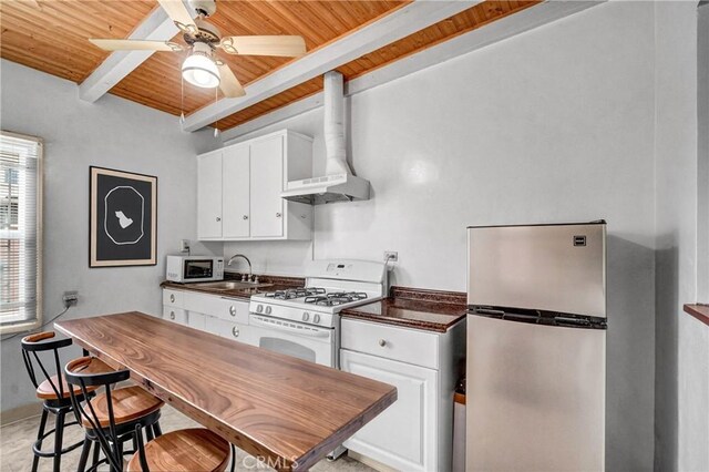 3224 Cerritos Ave, Signal Hill, CA 90755 - kitchen featuring white appliances, a wooden ceiling with exposed beams, dark countertops, wall chimney exhaust hood, and white cabinets