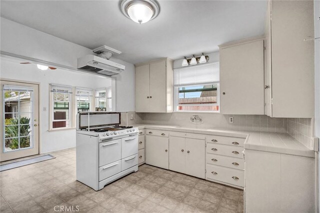 3224 Cerritos Ave, Signal Hill, CA 90755 - kitchen featuring white range with gas cooktop, tile countertops, light flooring, and healthy amount of natural light