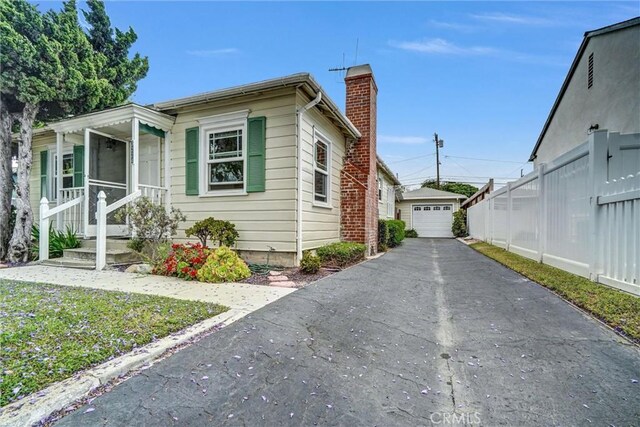 3224 Cerritos Ave, Signal Hill, CA 90755 - view of side of property featuring a chimney, a detached garage, an outbuilding, and driveway