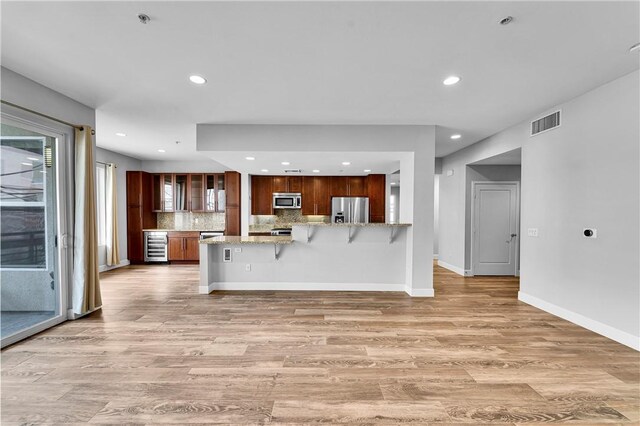 300 E 4th St Unit 204, Long Beach, CA 90802 - kitchen with appliances with stainless steel finishes, beverage cooler, a peninsula, light wood-type flooring, and recessed lighting