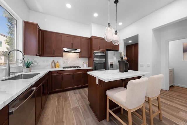 1686 Pember Ave, Chula Vista, CA 91913 - kitchen with stainless steel appliances, under cabinet range hood, light wood-type flooring, a breakfast bar, and recessed lighting