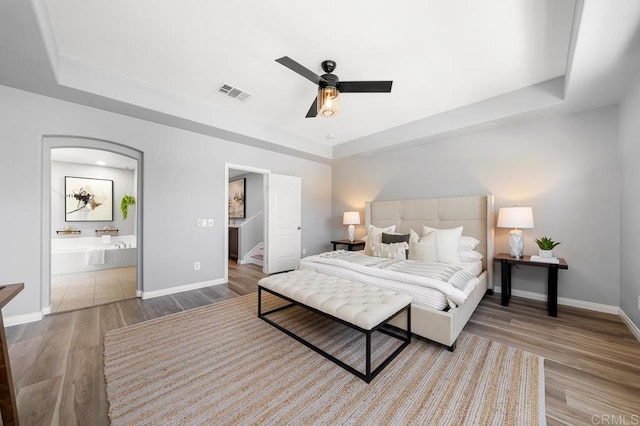 1686 Pember Ave, Chula Vista, CA 91913 - bedroom featuring a raised ceiling, wood finished floors, connected bathroom, and a ceiling fan