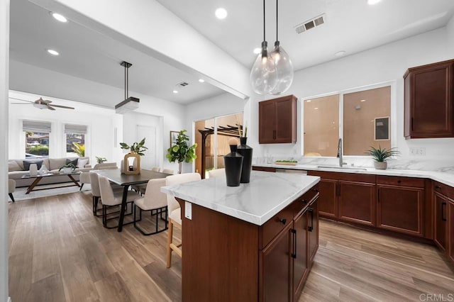 1686 Pember Ave, Chula Vista, CA 91913 - kitchen with a kitchen island, open floor plan, light wood finished floors, decorative light fixtures, and recessed lighting
