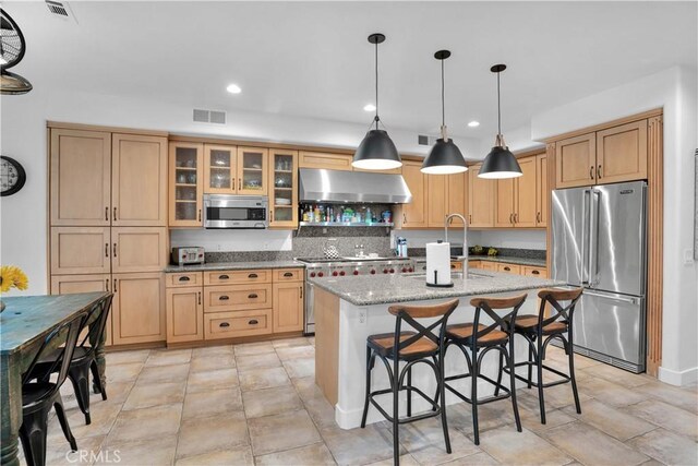 32811 Wesley St, Wildomar, CA 92595 - kitchen featuring high end appliances, exhaust hood, a center island with sink, a breakfast bar area, and a sink