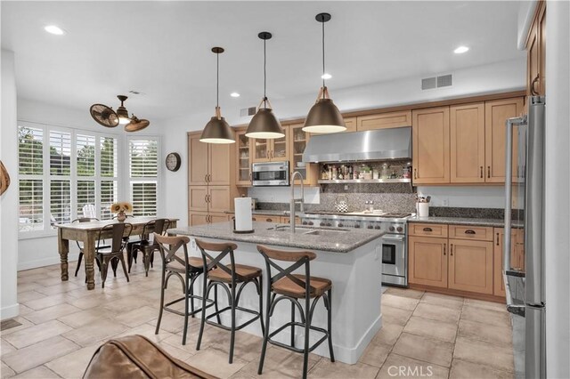 32811 Wesley St, Wildomar, CA 92595 - kitchen with extractor fan, stainless steel appliances, a sink, tasteful backsplash, and a kitchen breakfast bar
