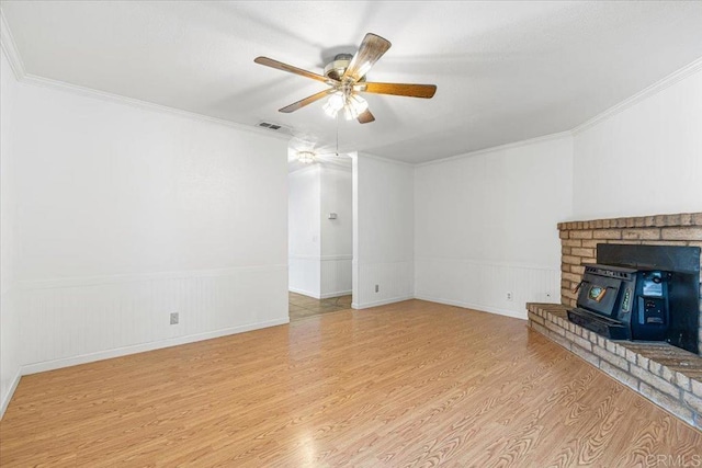 1105 Via Prado, Fallbrook, CA 92028 - unfurnished living room featuring wood finished floors, crown molding, ceiling fan, a wainscoted wall, and a wood stove