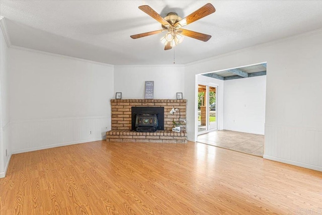 1105 Via Prado, Fallbrook, CA 92028 - unfurnished living room featuring wood finished floors, ornamental molding, ceiling fan, a wainscoted wall, and a wood stove