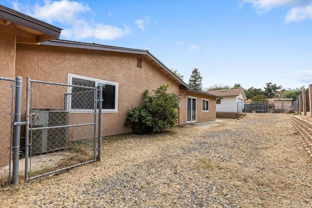 1105 Via Prado, Fallbrook, CA 92028 - back of house with stucco siding, a fenced backyard, and a gate