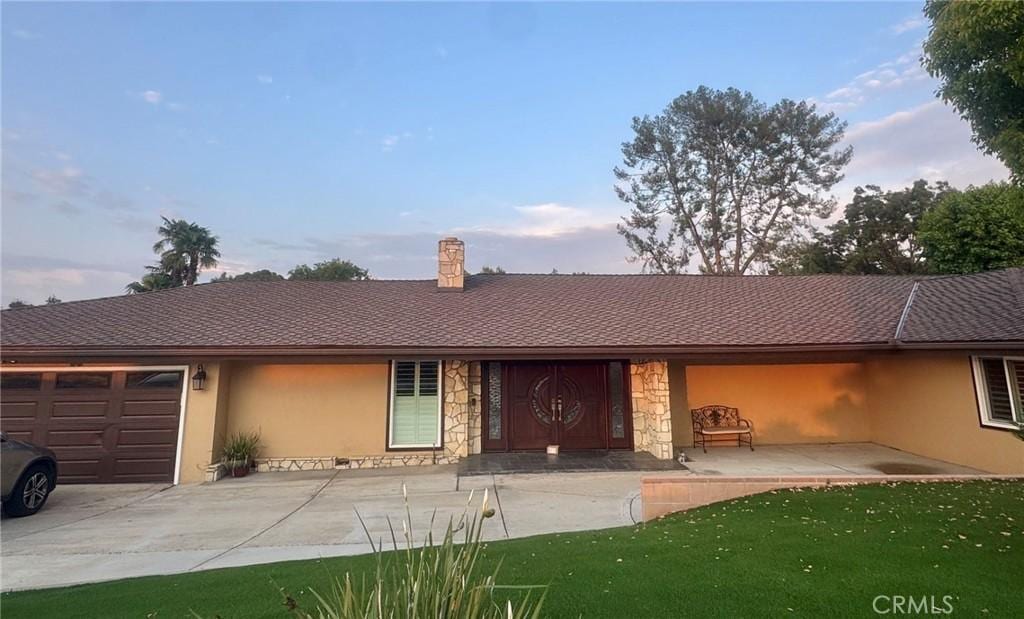 1020 S Montezuma Way, West Covina, CA 91791 - ranch-style house with stucco siding, a garage, stone siding, driveway, and a chimney