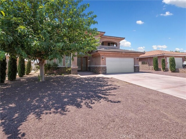 26775 Lakeview, Helendale, CA 92342 - view of front of home with stucco siding, concrete driveway, an attached garage, a tiled roof, and stone siding