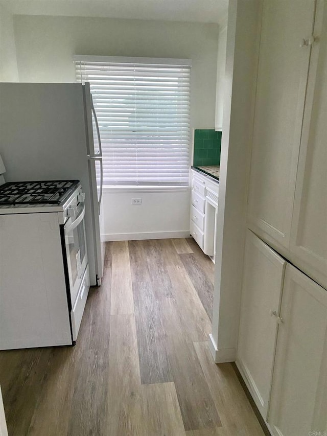 481848321/2 Palm Ave, La Mesa, CA 91942 - kitchen with white range with gas stovetop, light wood-style flooring, tasteful backsplash, and baseboards