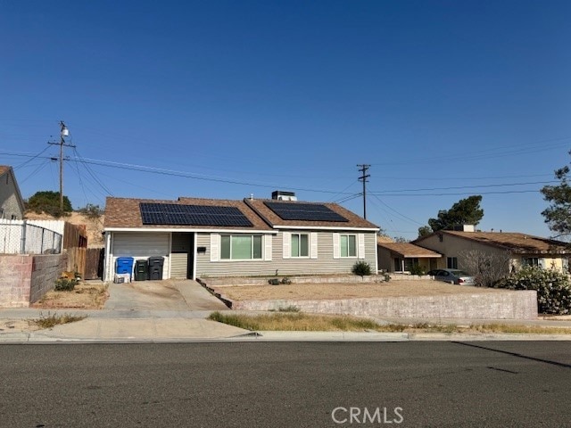 704 Belinda Ave, Barstow, CA 92311 - ranch-style house featuring driveway, solar panels, and an attached garage