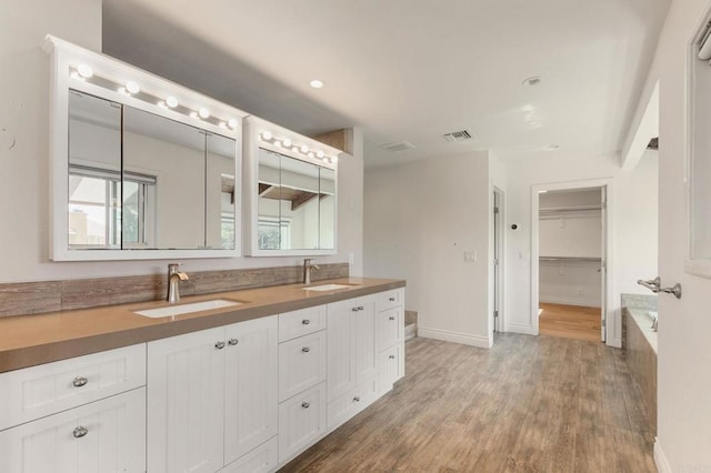 1628 Lone Oak Rd, Vista, CA 92084 - bathroom with wood finished floors, double vanity, baseboards, and a tub