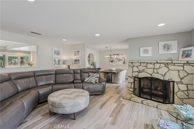 1926 N Vallejo Way, Upland, CA 91784 - living room with light wood-type flooring, a chandelier, recessed lighting, and a stone fireplace