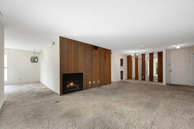 3213 Raintree Cir, Culver City, CA 90230 - unfurnished living room with a textured ceiling, carpet floors, a fireplace, and wooden walls