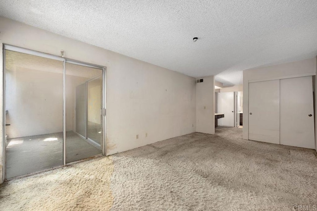 3213 Raintree Cir, Culver City, CA 90230 - unfurnished bedroom featuring a textured ceiling, two closets, and carpet