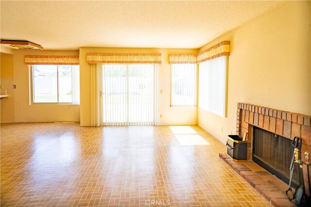 2868 Corte Caballos, Camarillo, CA 93010 - unfurnished living room with brick patterned flooring, a brick fireplace, a textured ceiling, and baseboards