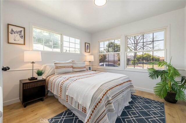 11012 Montgomery Ave, Granada Hills, CA 91344 - bedroom featuring multiple windows, light wood-style floors, and baseboards