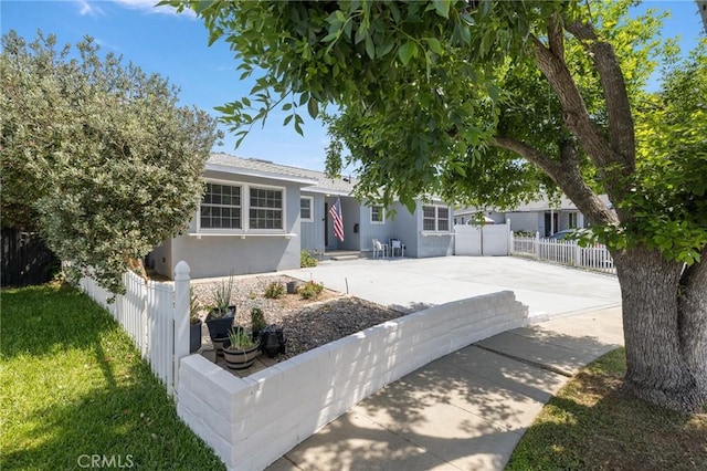 11012 Montgomery Ave, Granada Hills, CA 91344 - view of front of property with stucco siding, a patio area, and driveway