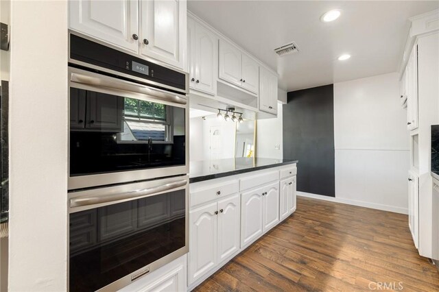 11012 Montgomery Ave, Granada Hills, CA 91344 - kitchen featuring stainless steel double oven, white cabinetry, dark wood-style flooring, dark countertops, and recessed lighting