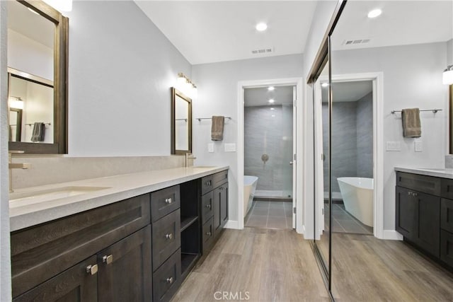 3520 Paseo Flamenco, San Clemente, CA 92672 - full bathroom featuring double vanity, wood finished floors, a shower stall, a freestanding bath, and baseboards