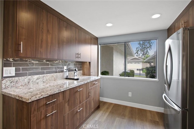 3520 Paseo Flamenco, San Clemente, CA 92672 - kitchen with freestanding refrigerator, baseboards, backsplash, light wood-style floors, and light stone countertops