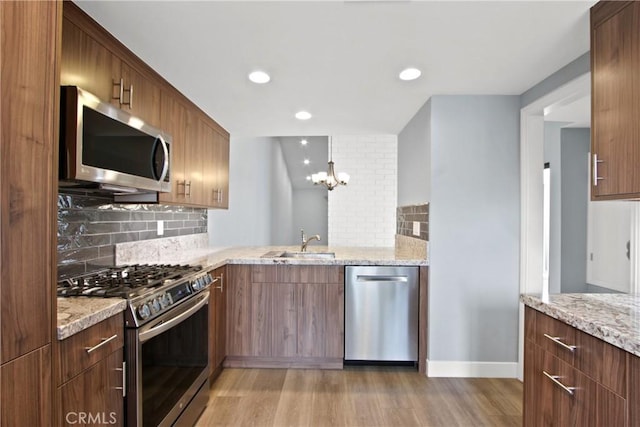 3520 Paseo Flamenco, San Clemente, CA 92672 - kitchen with appliances with stainless steel finishes, a sink, light wood finished floors, tasteful backsplash, and light stone countertops