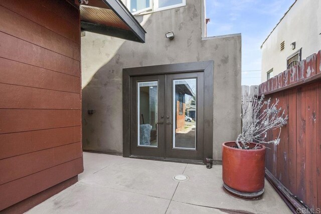 2211 Bancroft St, San Diego, CA 92104 - view of exterior entry with french doors, a patio area, and stucco siding