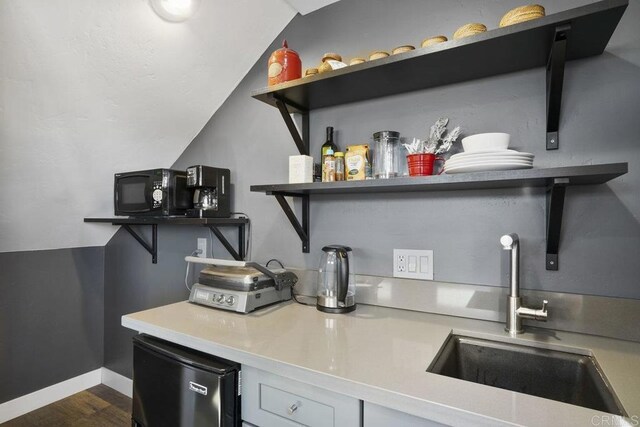2211 Bancroft St, San Diego, CA 92104 - bar featuring a sink, vaulted ceiling, fridge, dark wood finished floors, and baseboards