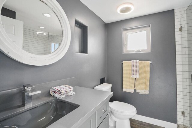 2211 Bancroft St, San Diego, CA 92104 - full bathroom featuring vanity, toilet, wood finished floors, and tiled shower