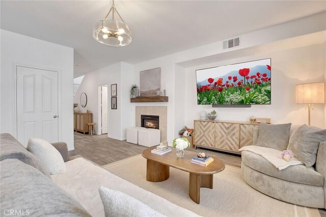 18026 Crabapple Ct, San Bernardino, CA 92407 - living room featuring wood finished floors, a chandelier, and a glass covered fireplace