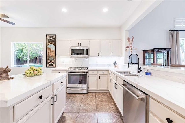 38260 Willow Ct, Murrieta, CA 92562 - kitchen featuring appliances with stainless steel finishes, a sink, plenty of natural light, light stone counters, and recessed lighting