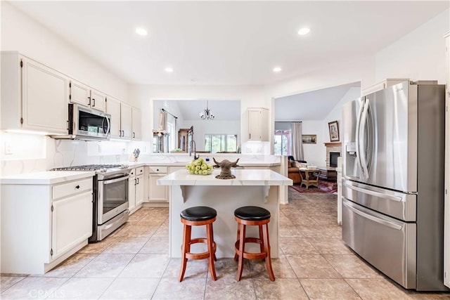 38260 Willow Ct, Murrieta, CA 92562 - kitchen featuring appliances with stainless steel finishes, light countertops, a chandelier, a kitchen breakfast bar, and white cabinets
