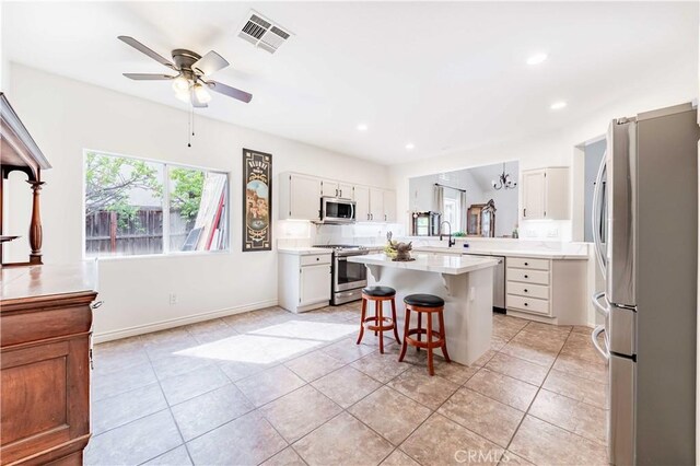 38260 Willow Ct, Murrieta, CA 92562 - kitchen featuring appliances with stainless steel finishes, a breakfast bar area, a ceiling fan, light countertops, and a kitchen island