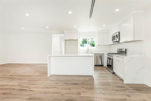 13934 Filmore St, Pacoima, CA 91331 - kitchen featuring appliances with stainless steel finishes, a sink, recessed lighting, light wood-style flooring, and white cabinets