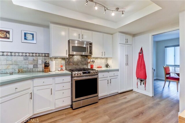 2032 E Bermuda St Unit 103, Long Beach, CA 90814 - kitchen with appliances with stainless steel finishes, a raised ceiling, light countertops, and backsplash